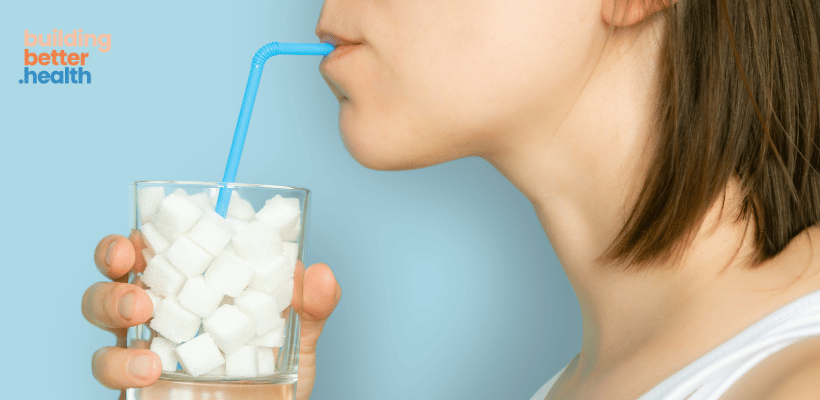 Woman drinking a glass of sugar cubes.  Wants to stop eating sugar in the new year.