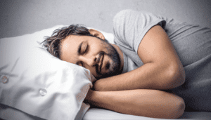 Man looking comfy in bed after learning how to get more sleep.