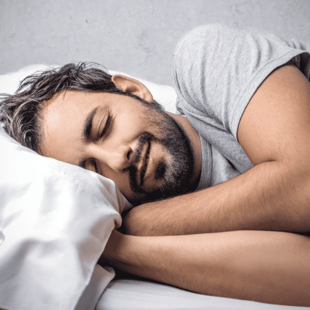 Man looking comfy in bed after learning how to get more sleep.