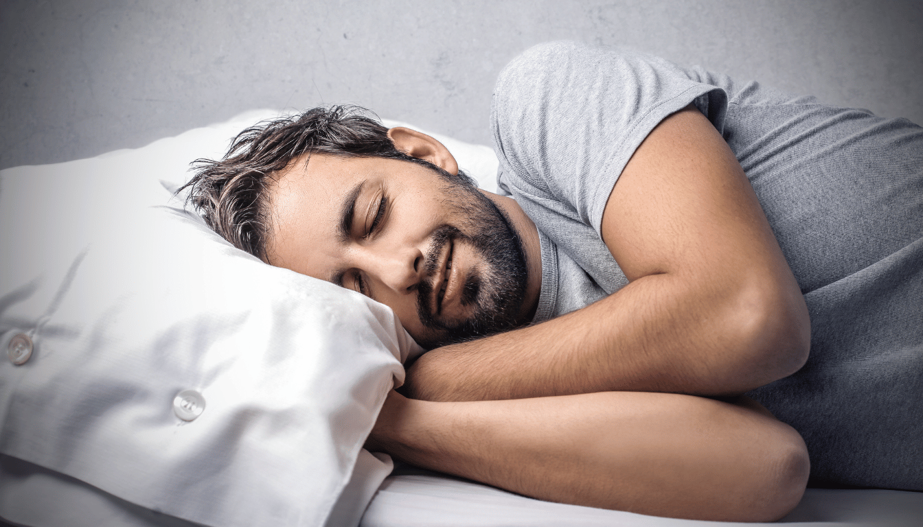 Man looking comfy in bed after learning how to get more sleep.