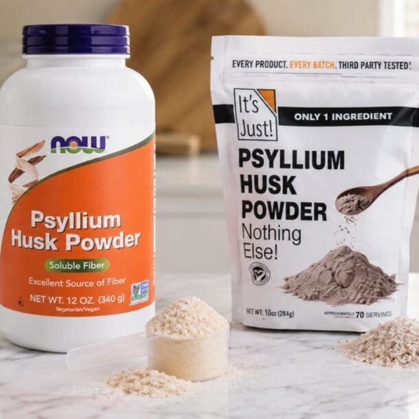 Two containers of psyllium husk powder, ideal for psyllium husk weight loss support, sit on a marble counter. One is a large NOW bottle and the other an It's Just! pouch, each with scoops of powder in front and fruits blurred in the background.